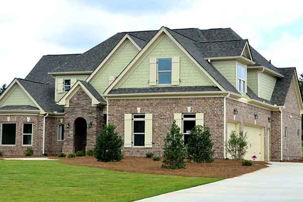 A brick single-family home with a well-kept lawn and driveway